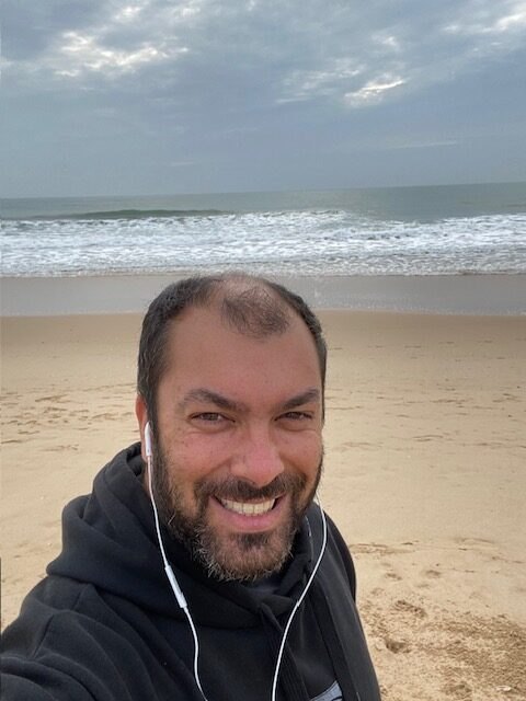 Pedro Martins smiling in a selfie on a beach